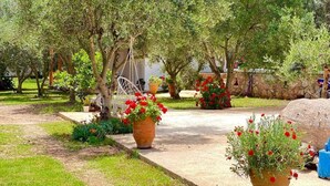 A garden pathway with potted plants and trees. - Rida Village Ksamil Island (Ksamil)
