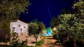 A pathway lined with trees and a building with a white facade. - Rida Village Ksamil Island (Ksamil)