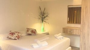 A modern bedroom with a large bed, a bedside table, a nightstand, a green vase, and a wooden wardrobe. - Rida Village Ksamil Island (Ksamil)