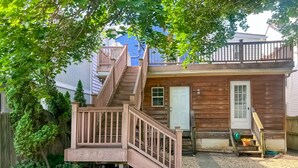 Ein Holzhaus mit einer Treppe, die zu einer Veranda führt.
