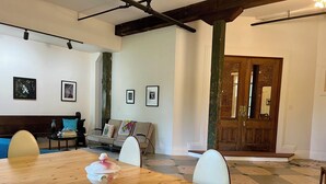 A dining area with a wooden table, chairs, and a bench. There are framed pictures on the wall and a door with a mirror. - Spacious, artist-designed apartment in 1890s chocolate factory. DOG FRIENDLY! (Hopewell)
