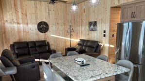A modern kitchen with a marble countertop, black leather seating, and a stainless steel refrigerator. - Newly built in Devils Lake, Perfect for Fishing or Relaxing (Devils Lake)