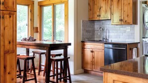A kitchen with wooden cabinets, a granite countertop, and a built-in dishwasher.