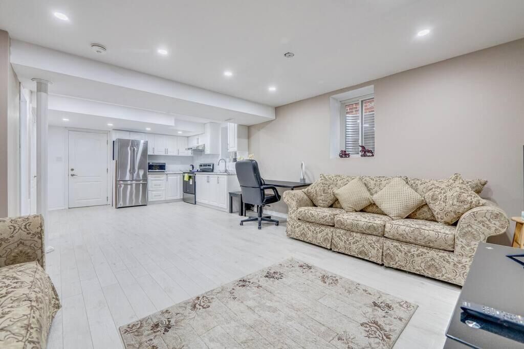 A modern living room with a sofa, a coffee table, and a dining area with a table and chairs.