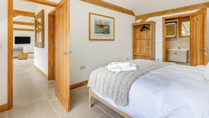 Un dormitorio con una cama, un armario de madera, un espejo y un televisor.