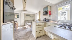 A modern kitchen with a built-in microwave, a sink, and a window with a view.