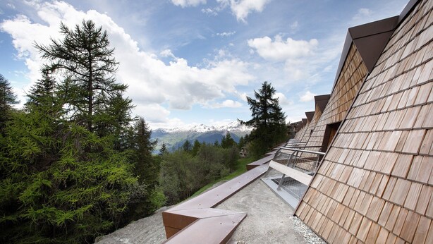 A pathway leading to a building with a view of snow-capped mountains and dense forest. - Apartment 'Larice' with Mountain View, Private Terrace and Shared Garden (Pila)