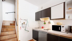 A kitchen with a microwave, sink, and cabinets. - Apartment 'Larice' with Mountain View, Private Terrace and Shared Garden (Pila)