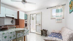A compact living space with a dining area, kitchenette, and a sofa.