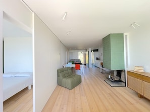 Un espacio habitable moderno y abierto, con sofá, zona de comedor y cocina.