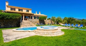 Una casa con piscina, escalones de piedra y un muro de piedra.