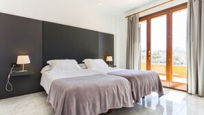 Una habitación de hotel con dos camas, un ventanal grande y vistas a la ciudad.