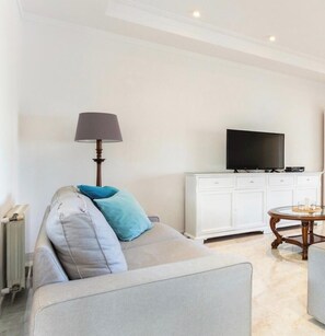 A living room with a sofa, a lamp, a TV, a cabinet, and a round table. - Villa 'Ca Nostra' with Private Pool, Shared Terrace and Wi-Fi (Son Servera)