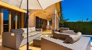 A sunlit outdoor seating area with a pool, a dining area, and a view of the surrounding landscape. - Villa 'Ca Nostra' with Private Pool, Shared Terrace and Wi-Fi (Son Servera)
