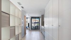 A hallway with a sliding door leading to an outdoor area, a kitchenette with white cabinets, and a tiled floor. - Apartment 'Apartamento Pachimon' with Shared Pool, Wi-Fi and Air Conditioning (Conil de la Frontera)