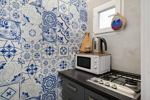 Une cuisine équipée d’un four à micro-ondes, d’un grille-pain et d’une cuisinière à gaz.