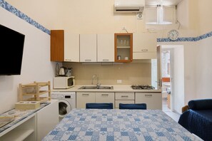 A compact kitchen with a sink, microwave, and a small cabinet. - Apartment 'Penisola  1' with Shared Terrace, Wi-Fi and Air Conditioning (Vico Equense)