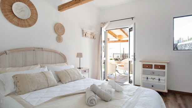 A bedroom with a bed, a dresser, a window, and a door leading to a balcony. - Holiday Home 'Las Golondrinas - B' with Sea View, Private Terrace and Wi-Fi (Jedey)