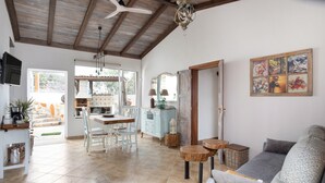A spacious living area with a sofa, dining table, chairs, and a kitchen in the background. - Holiday Home 'Las Golondrinas - B' with Sea View, Private Terrace and Wi-Fi (Jedey)
