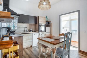 A modern kitchen with a wooden island, built-in appliances, and a dining area with a table and chairs.