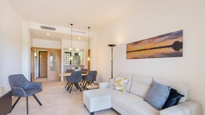 A modern living room with a sofa, chairs, and a dining area.