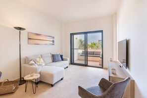 A modern living room with a sofa, a coffee table, a floor lamp, and a TV. - Apartment 'El Oasis Martinica 8 Bajo A' with Shared Pool, Wi-Fi and Air Conditioning (Fuente Alamo)
