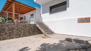Un edificio moderno con un muro de piedra, una escalera y un letrero que dice 'Solymar Privé'.