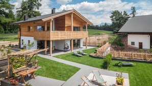 A wooden house with a balcony, a garden with a swing, and a small shed. - Apartment 'Larch' with Mountain View, Shared Garden and Wi-Fi (Jenesien)