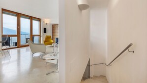 Un intérieur moderne avec un escalier, un balcon offrant une vue agréable et des meubles contemporains.