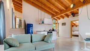 Uma sala moderna com sofá, área de jantar e cozinha.