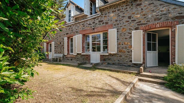 A stone building with a rustic appearance, featuring multiple windows with shutters, a small porch, and a well-maintained lawn. - Holiday Home 'Maison Pleneuf Val André Proche Mer' with Private Terrace, Private Garden and Wi-Fi (Pléneuf-Val-André)