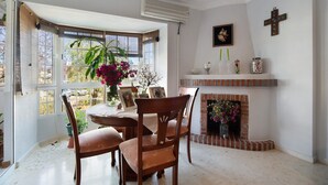 Un comedor con una mesa, sillas, chimenea y un ventanal grande.