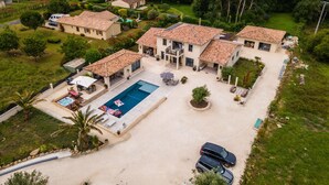 Propiedad residencial con piscina, varias casas y un lago al fondo.