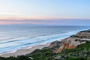 Un paysage côtier avec une plage, des falaises et l’océan.