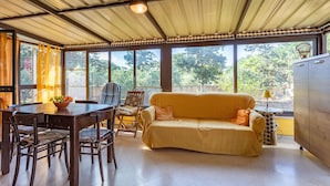 Ett rum med ett matbord, stolar, en soffa och ett skåp.