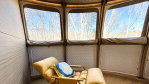 A cozy interior with a yellow rocking chair, a quilted mattress, and a window with a forest view. - Countryside Getaway Sand UniqueDomeB/serene farm retreat (Snow Camp)