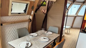 A dining area with a table set for four, equipped with plates, cutlery, and glasses. - Countryside Getaway Sand UniqueDomeB/serene farm retreat (Snow Camp)