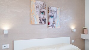 Un dormitorio con cama, dos lámparas fijadas a la pared y un enchufe en la pared.