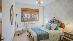 A bedroom with a wooden bed, a window, a radiator, and a bedside table. - Country House 'El Corcal' with Mountain View, Private Terrace and Wi-Fi (Triollo)