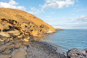 Un paisaje costero con acantilados rocosos y un mar azul cristalino.