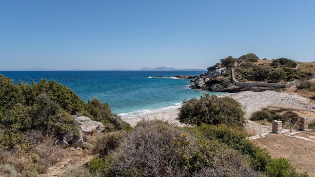 A coastal landscape with a rocky beach, dense greenery, and a clear view of the sea. - Black Sand Holiday Home with Sea View and Private Terrace (Naxos)