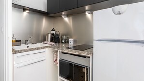 Una cocina moderna con horno integrado, microondas, lavaplatos y una cocina por inducción negra.