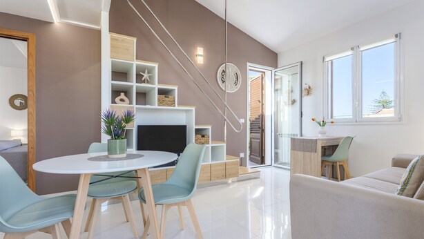 Un salon moderne comprenant un coin repas, un escalier et une vue sur l’extérieur.
