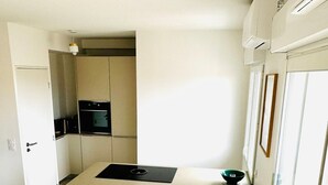 A compact kitchen with a built-in oven, a sink, and a small countertop.