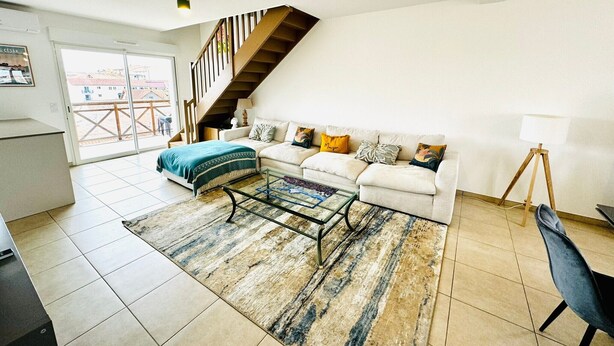 A living room with a sofa, coffee table, and a staircase.