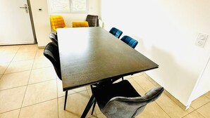 A dining area with a rectangular table, six chairs, and a window with a view.
