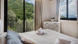 Un dormitorio con cama, una mesita de noche y vistas a un paisaje montañoso.