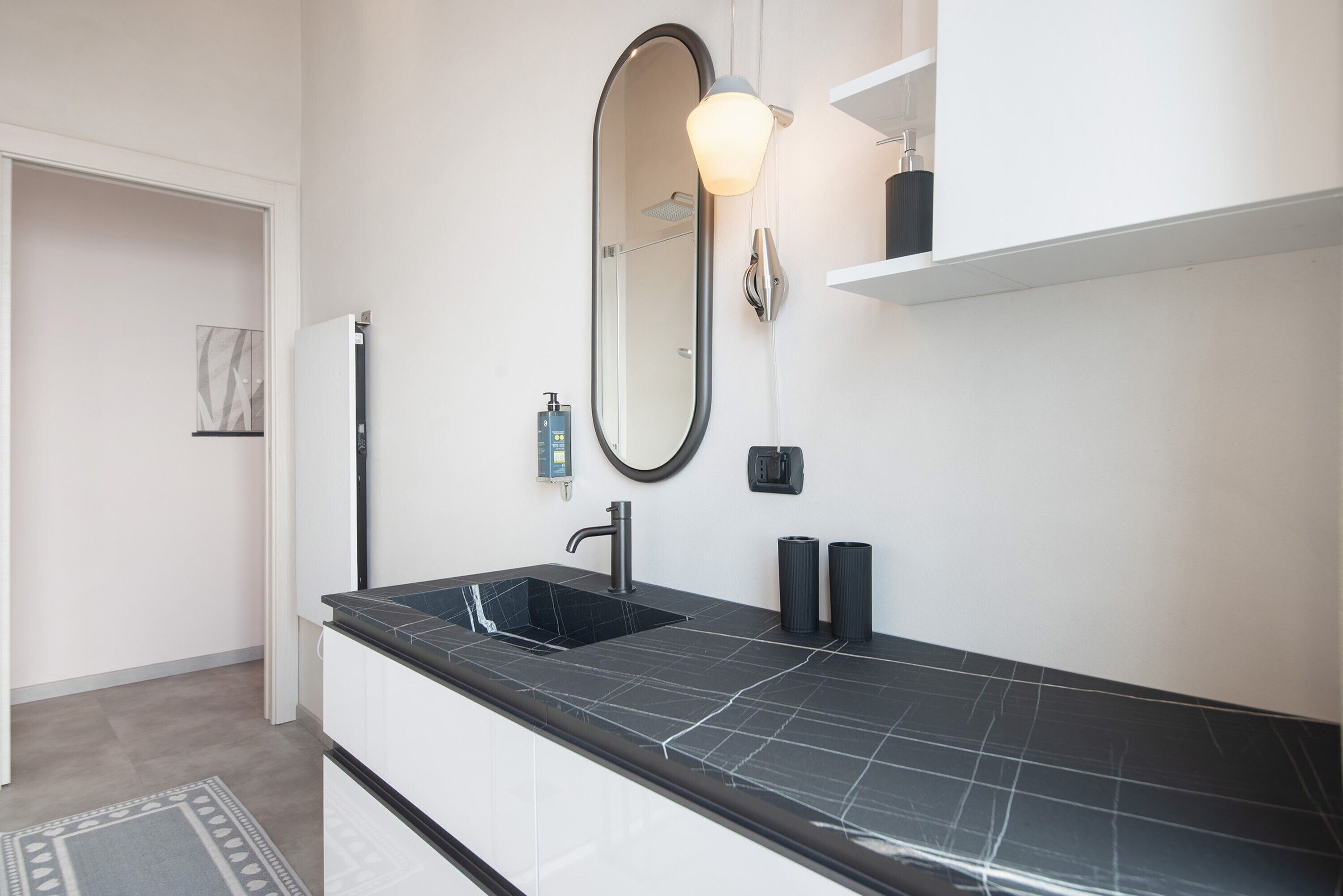 A modern bathroom with a black sink, a large mirror, and a towel rack.