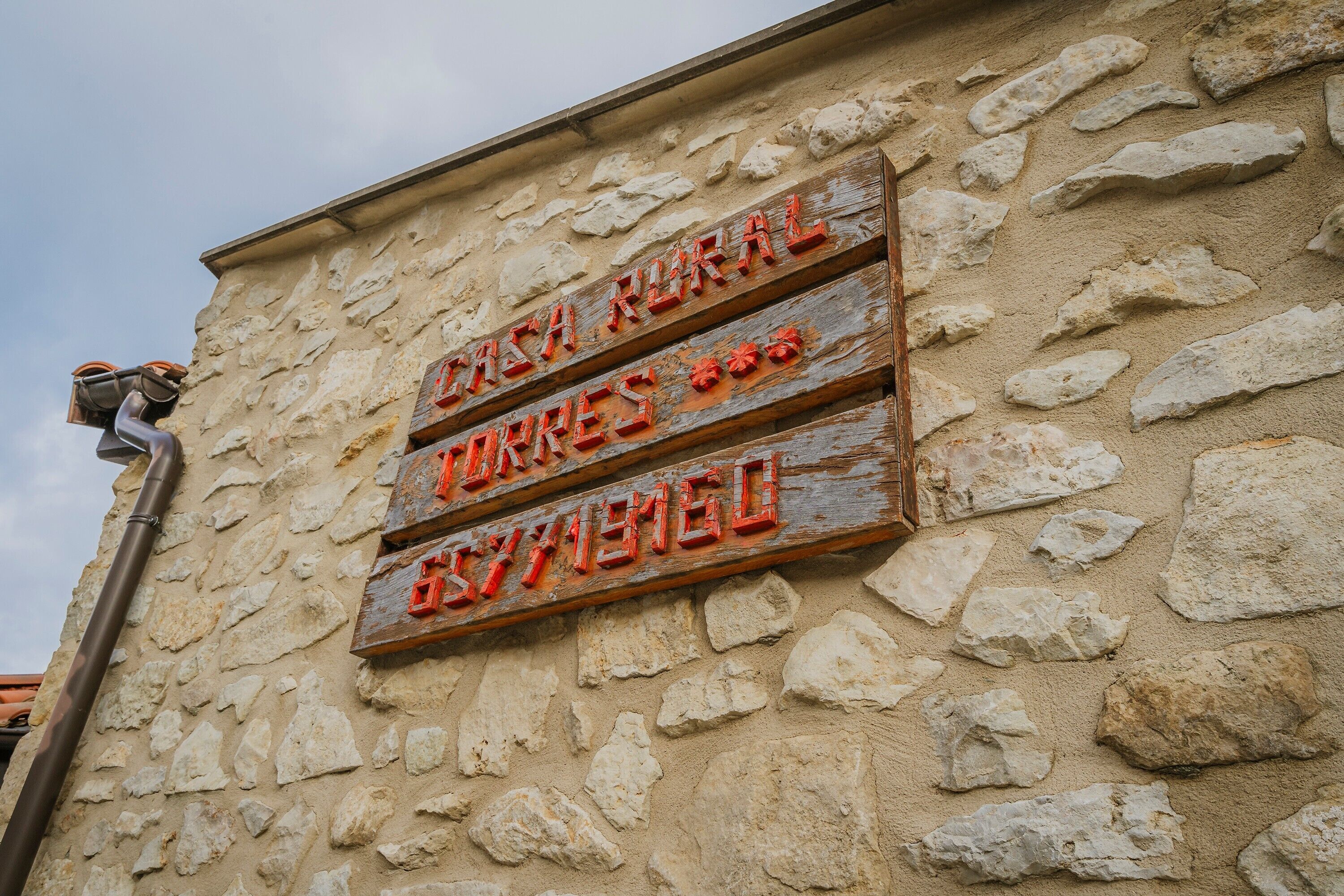En stenvæg med et skilt, der står 'RURAL' og 'RURAL HOTEL'.