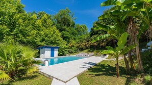 A swimming pool with a small blue structure, surrounded by lush greenery and a clear blue sky. - Apartment 'Appartement Dans Maison Urcuit' with Mountain View, Private Pool and Wi-Fi (Urcuit)